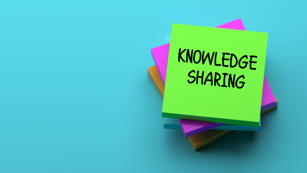 Stack of post-it notes with the word 'Knowledge sharing' written on it. 